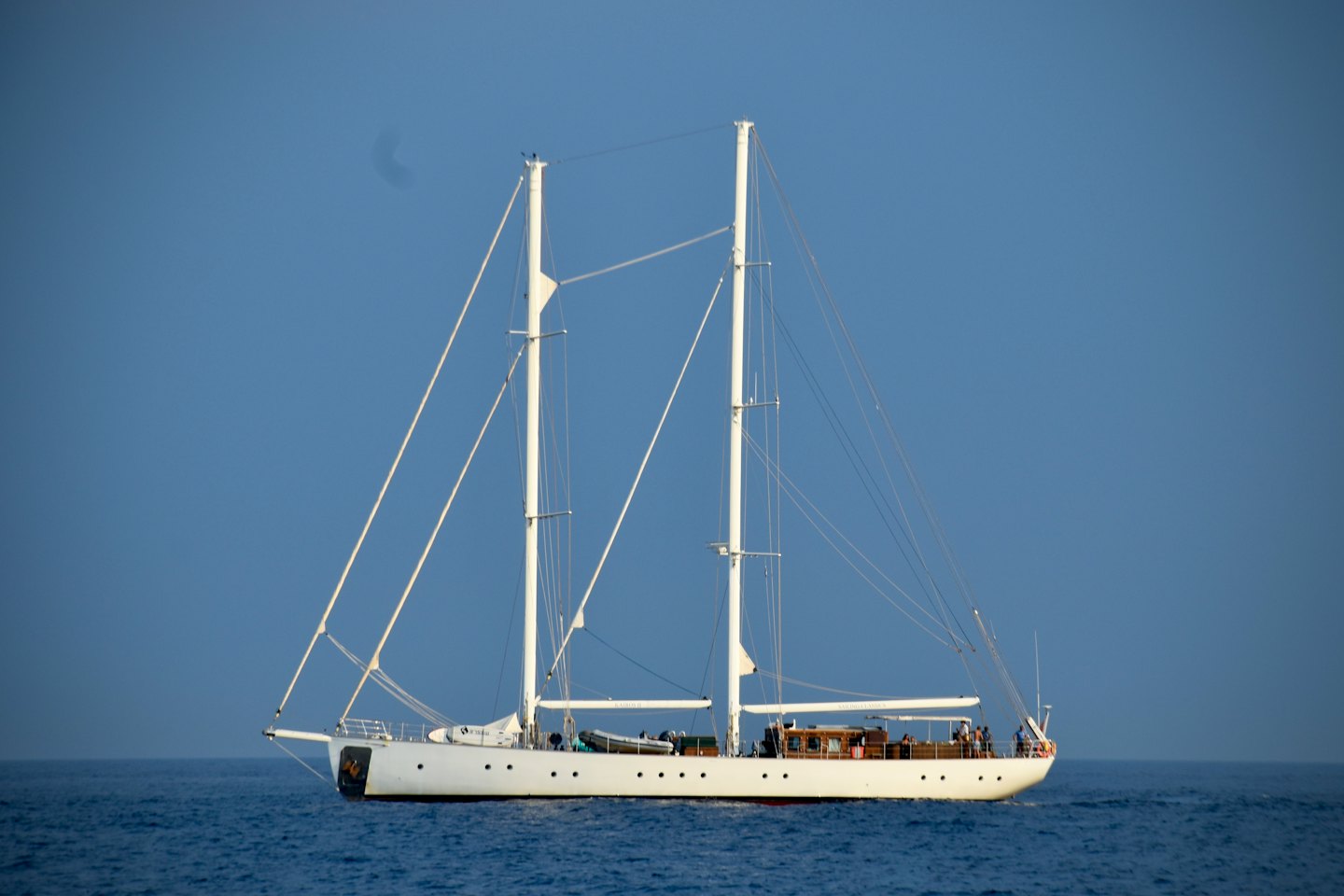 Dvouplachetnicová bílá jachta pluje po širém oceánu.